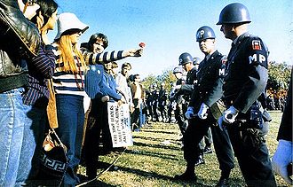 Make love not war - demonstrators offer a flower to Military Policemen confronting them